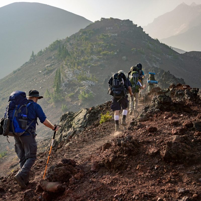 pexels-photo-1365425-1365425 Group of hikers trekking on a rugged mountain trail in Oregon's scenic outdoors.