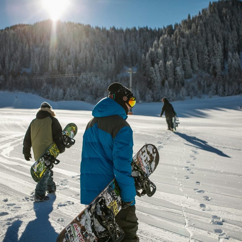 pexels-photo-848612-848612 Group of snowboarders walking up a snowy ski slope during a sunny winter day in the mountains.